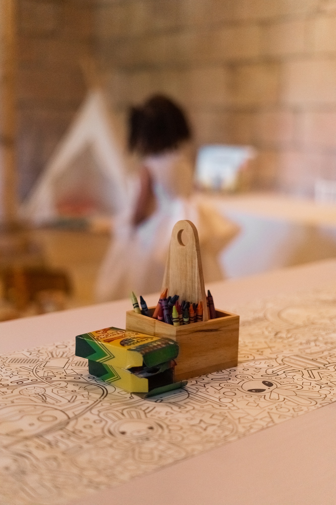 Wooden crayon and coloring station in a wedding kids area