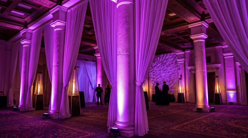 Purple LED uplighting washing classical ballroom columns at a South Florida event